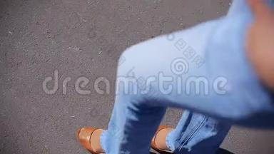 穿着蓝色牛仔裤和棕色鞋子的女孩在柏油路上散步，俯瞰<strong>美景</strong>