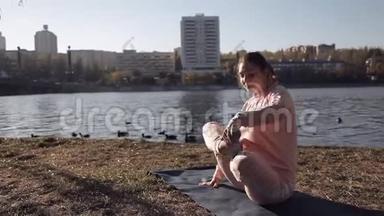 在河边公园里做瑜伽的女孩