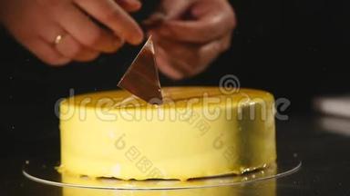 蛋糕的细节。 巧克力和椒盐卷饼。 刚做的蛋糕。 糖果师旋转蛋糕并装饰它。 黄色