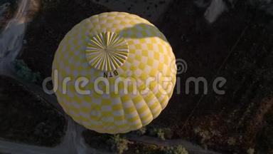 一个黄色的大气球的跨度，在一个人的篮子里，特写.. 飞越群山-卡帕多西亚全景