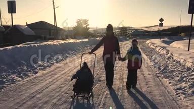 十几岁的女儿和母亲拉着小儿子在雪橇上跑。 <strong>剪影</strong>一<strong>家人</strong>在冬天玩。 积极健康