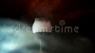干冰效果，酒玻璃在黑色背景上溢出蒸汽烟雾，在玻璃棒上翻腾