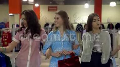 三个兴高采烈的年轻女人穿着五颜六色的衣服穿过一家<strong>百货公司</strong>。