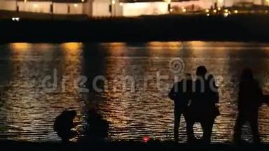 夜晚的人们在城市靠近河流，夜晚的灯光背景