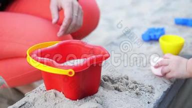 幼儿的手在户外玩动态沙.. 儿童造型。 生活方式和夏季理念..