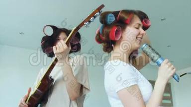两个滑稽女孩用梳子缓慢地唱歌，用电吉他跳舞唱歌