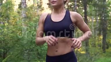 女运动员的特写肖像。 肌肉发达的女孩在黎明<strong>时</strong>在夏天的森林里慢跑。 慢动作
