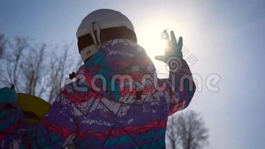 大气框架，梦想和欢乐的概念。 一个滑雪的女孩用手抓住了一个明亮的太阳。 A.