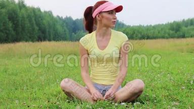 美丽的女孩坐在绿色的草地上，在<strong>夏天</strong>的<strong>夜晚</strong>欢乐