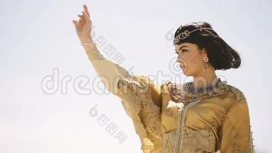 美丽的女人，有时尚的化妆和发型，像埃及女王克利奥帕特拉在户外对抗天空