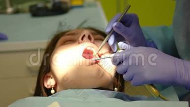 牙医检查年轻女孩的口腔，用嘴唇<strong>推动</strong>仪器。 4k. 3840x2160