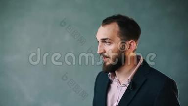 穿着夹克和条纹衬衫的大胡子男人，在孤立的背景下接受<strong>采访</strong>