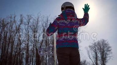 大气框架，梦想和欢乐的概念。 一个滑雪的女孩用<strong>手</strong>抓住了一个明亮的太阳。 A.