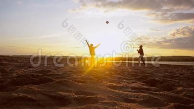 训练男子在阳光下在沙滩上打排球，夏天晚上在沙滩上打排球。