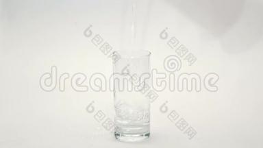 将水倒入白色背景的玻璃杯中。 倒入玻璃的水