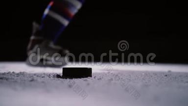 职业冰球运动员在冰场上射门. 特写镜头。 慢动作