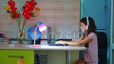 小<strong>女孩</strong>带着耳机在笔记本电脑上玩<strong>网络</strong>游戏。 电脑上的小<strong>女孩</strong>在<strong>社交</strong>媒体上留言