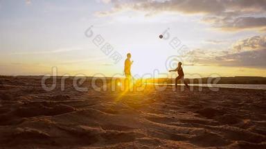 男子在阳光下的沙滩上打排球，夏天的傍晚打沙滩排球..