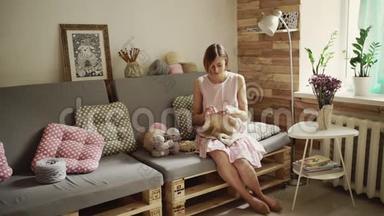 年轻女子坐在沙发上编织羊毛衫