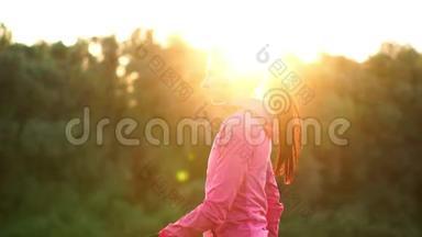 一个穿着粉色夹克的女孩<strong>正在准备</strong>跑步热身，通过电话用耳机听音乐