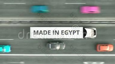 从高空<strong>俯视</strong>半挂<strong>车</strong>卡<strong>车</strong>与埃及制造文本沿道路行驶。 埃及商业