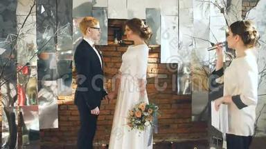 新娘和新郎在婚礼上亲吻登记员致辞后。 室内庆祝活动