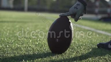 球场上橄榄球的特写镜头抓住了一个男人`手