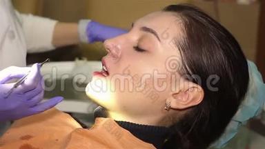 在牙科诊所有扩张器的年轻女子。 保护美白凝胶在牙齿上的应用。