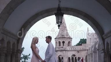 在匈牙利布达佩斯的宏伟城堡里，一对相爱的情侣轻轻拥抱在一起。 蜜月概念