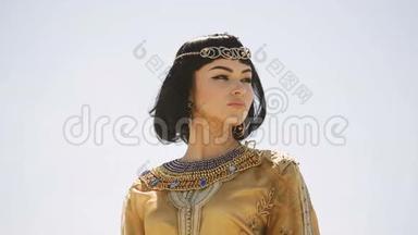 美丽的女人，有着时尚的妆容和发型，像埃及女王克利奥帕特拉在户外抵御沙漠大风天气