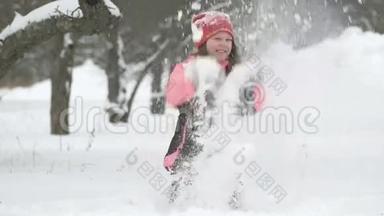 快乐的孩子在雪地里玩耍的慢动作。 快乐的女孩在冬日外面玩得开心