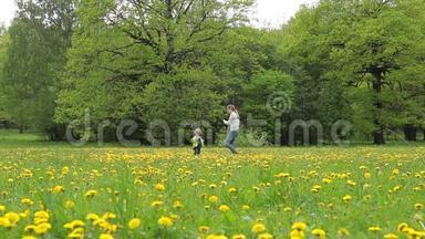 一个带着孩子的年轻女人正带着蒲公英在田野里走来走去。