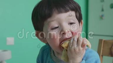 有趣的小男孩在家吃奶油煎饼