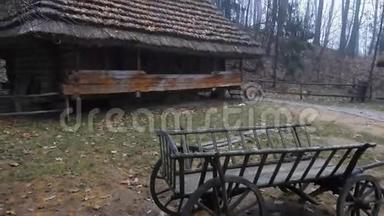 瓦格纳马旧木车靠近旧的传统欧洲木屋，屋顶有茅草