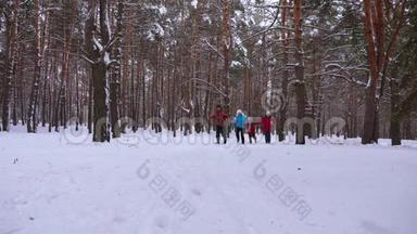 快乐的孩子和爸爸妈妈和孩子们一起在冬天的森林里跑步。 父母在雪地公园里玩孩子