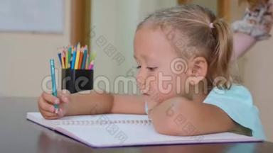 小可爱的女孩坐在教室里写<strong>作业本</strong>