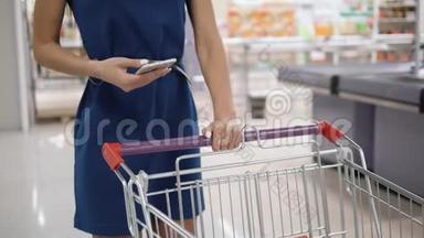 在超市<strong>购物</strong>时使用手机的女人，在<strong>购物</strong>中心<strong>购物</strong>店<strong>购物</strong>