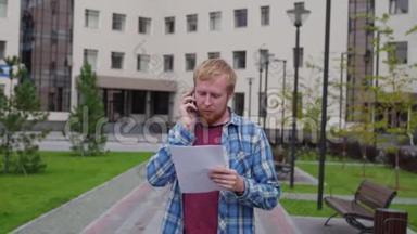 一个年轻的学生来到大学的背景下，打电话，拿着重要的文件