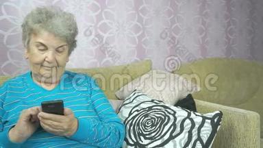 使用手机的老年妇女坐在沙发上
