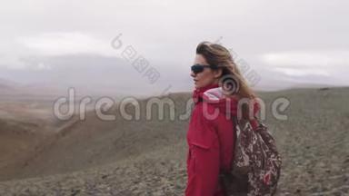 在倾盆大雨下的山上旅行者的肖像。 一个旅游女孩独<strong>自带</strong>着背包在高地