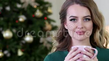 一个年轻女子喝茶的肖像，快乐的女孩喝茶，微笑着看着镜头，在客厅附近