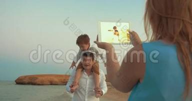 母亲带着垫子射击，父亲和儿子在海滩上