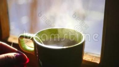 在装有蒸汽的<strong>杯子</strong>里，把美味的红茶叶放在<strong>热水</strong>袋里，站在窗户附近，动作缓慢