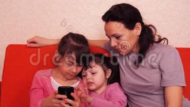 妈妈和女儿玩手机。 幸福的家庭玩手机。