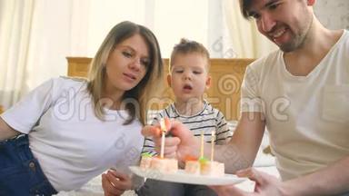 <strong>一家人</strong>笑着<strong>一起</strong>庆祝儿子的生日，然后在蛋糕上点蜡烛
