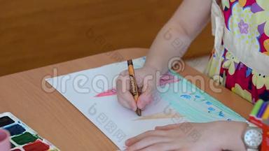 孩子的手在用彩色铅笔画画。 画铅笔，孩子们学习世界，画房子，树，太阳