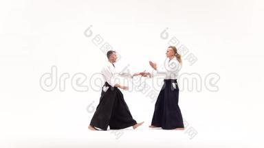 两个<strong>穿和服</strong>的男人练习合气道的技巧，被隔离在白色上。 慢动作。
