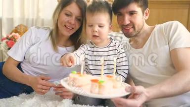 一<strong>家人</strong>笑着<strong>一起</strong>庆祝儿子的生日，然后在蛋糕上点蜡烛