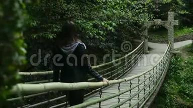 女孩在<strong>茂密的森林</strong>中上吊桥