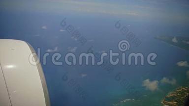 多米尼加共和国从飞机窗口俯瞰。 在飞机机翼下可见加勒比海海岸